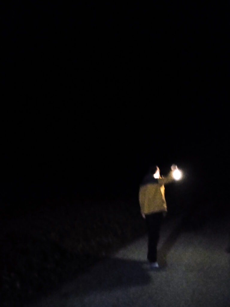 une figure dans le noir, qui tient une lanterne