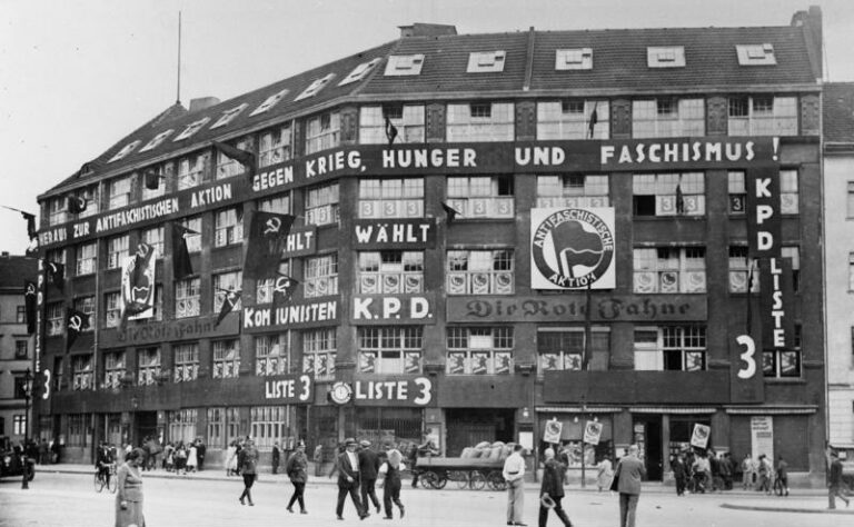Photographie de la "Maison Karl Liebknecht", quartier général du KDP de 1926 à 1933. Le logo "action antifasciste" est placardé à la façade.